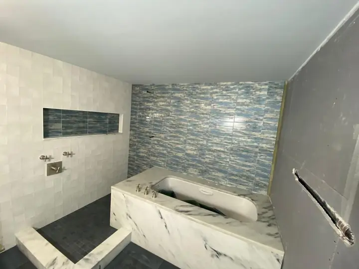Tub surround with a blue glass mosaic accent wall