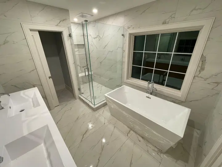 Bathroom with a freestanding tub and large-format marble-style floor