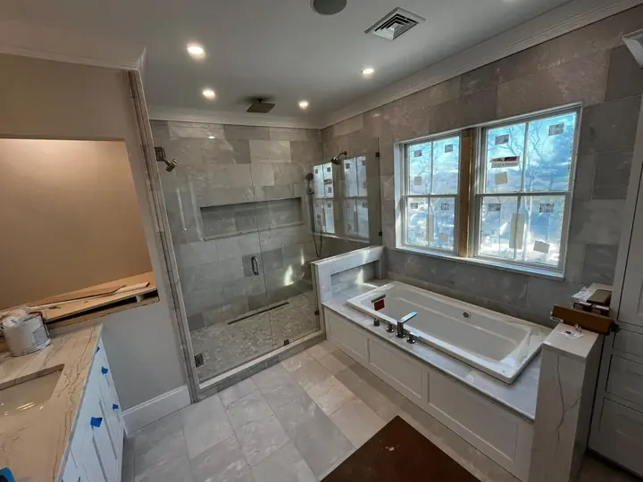 Bathroom with a glass shower and tiled tub platform