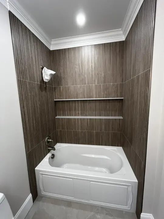 Tub surround in wood-look tile with a built-in shelf