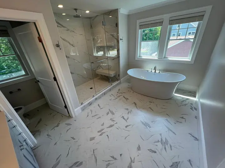 Bathroom with a freestanding tub and veined marble-style floor
