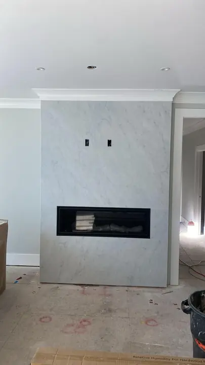 Linear fireplace wall in large-format marble-style tile