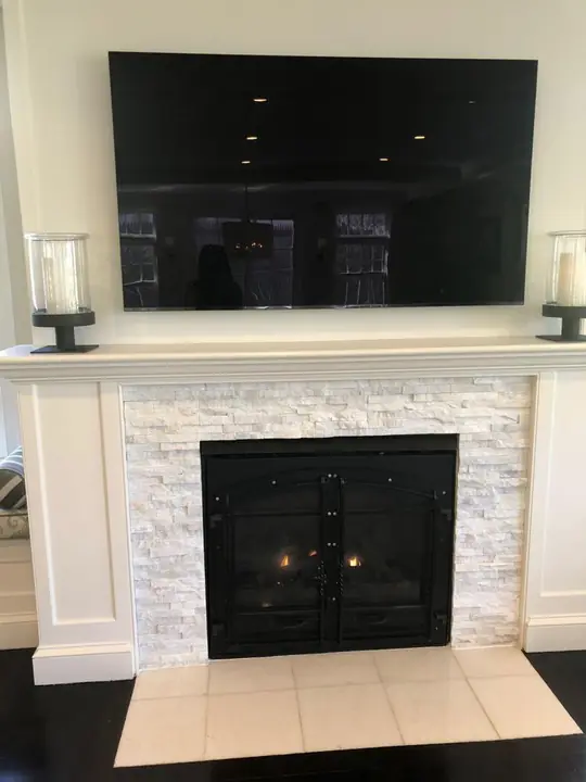 Fireplace with a stacked-stone surround and tile hearth