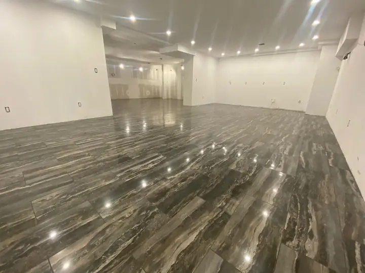 Glossy wood-look plank tile floor in a large open room